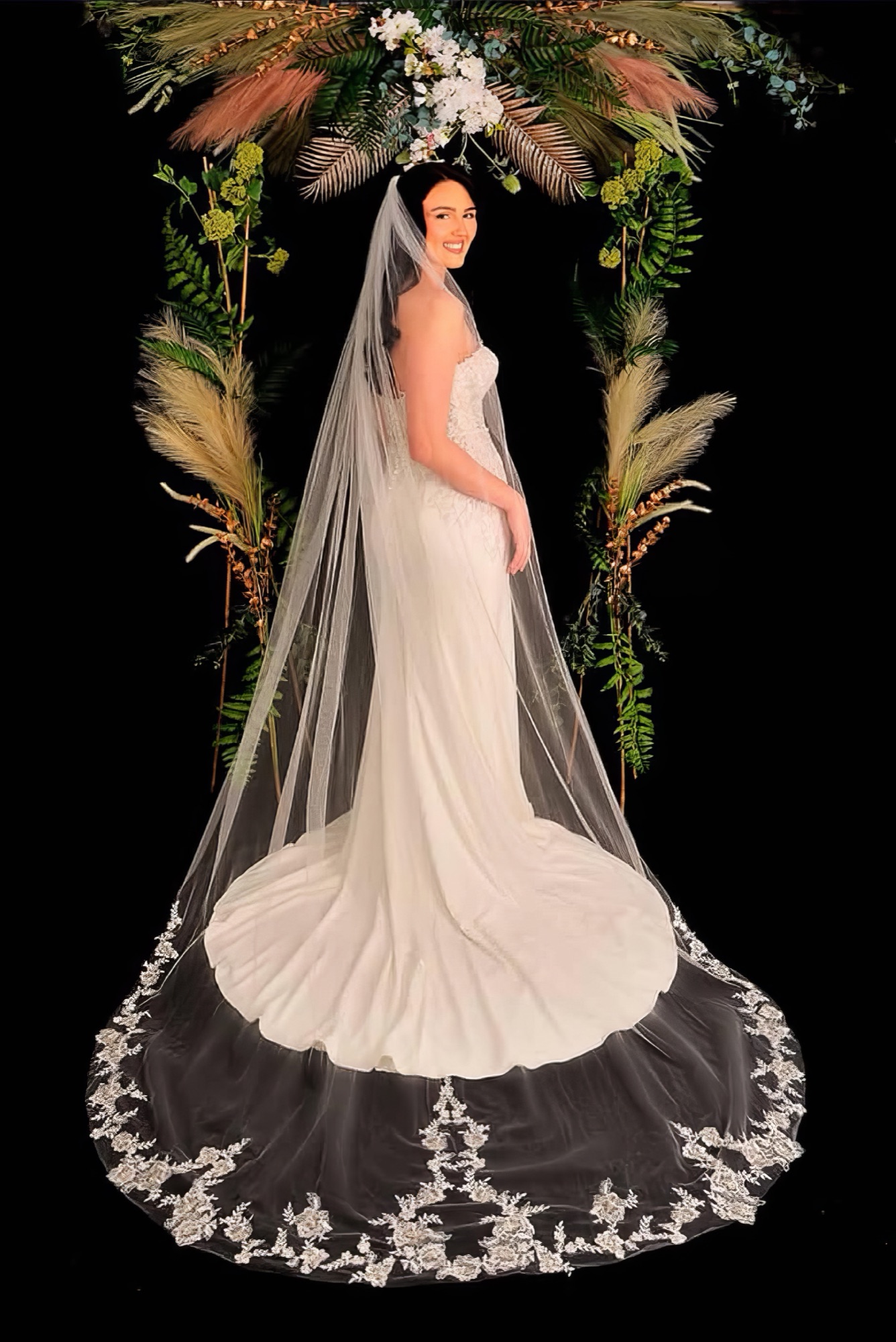 Bride wearing a long lace-edged cathedral veil